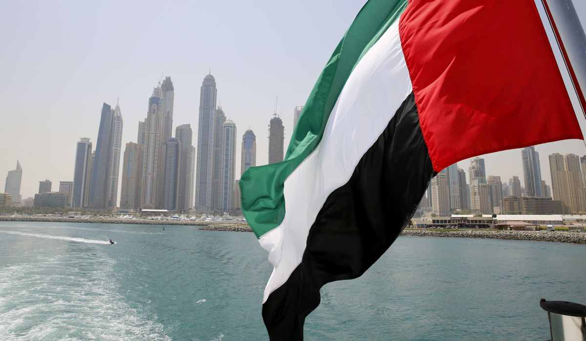 UAE flag flies over a boat at Dubai Marina